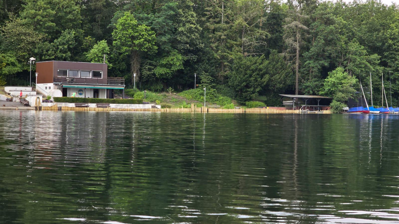 Bewaldetes Ufer und Vereinsgelände am Heider Bergsee
